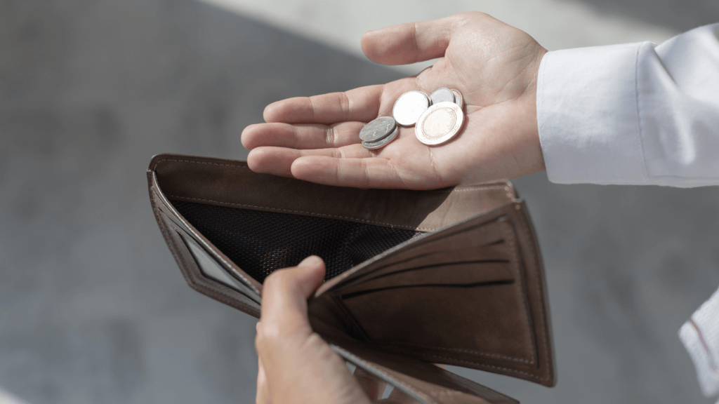 a man holding his wallet and coins in his hand